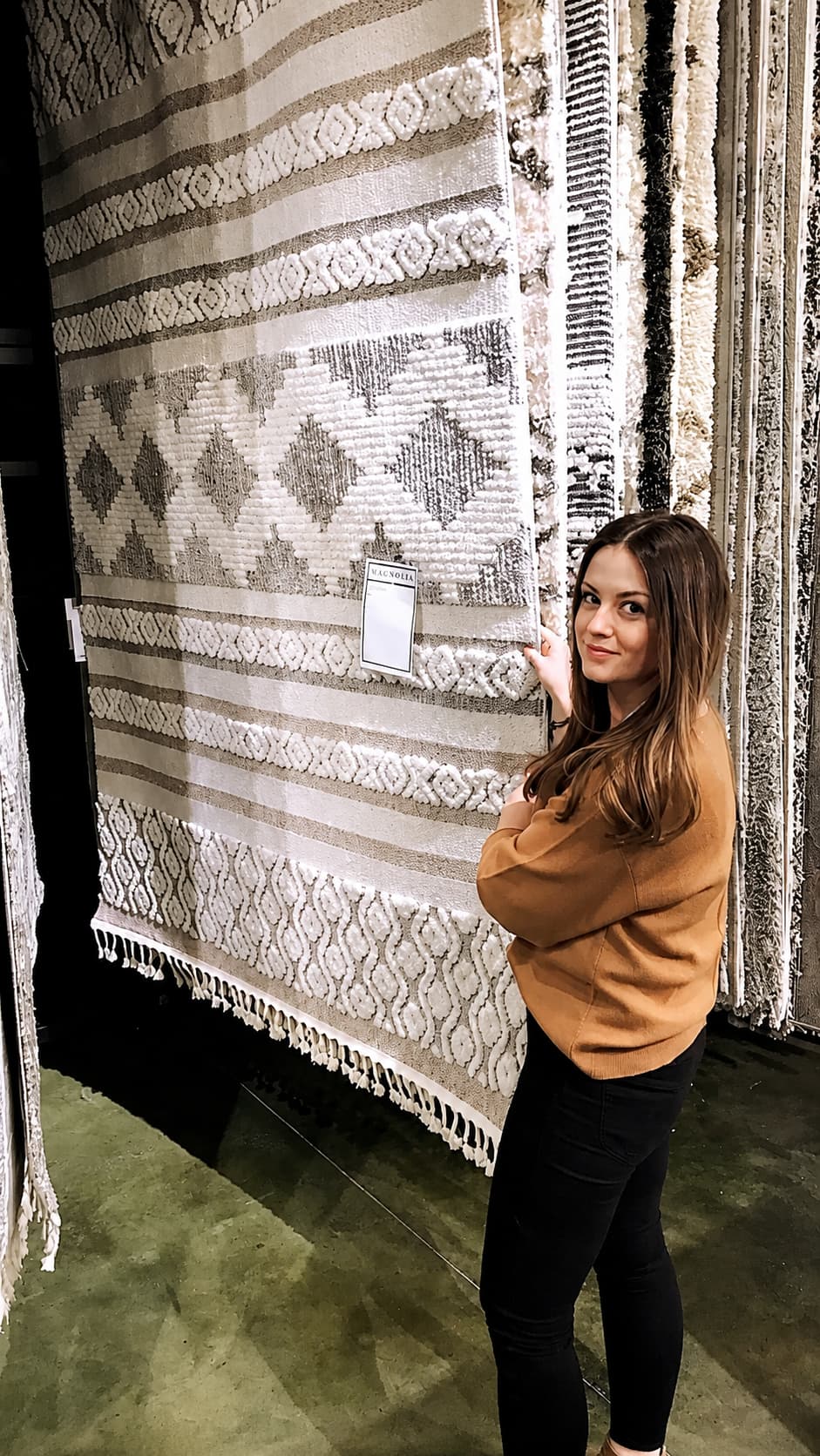 Kristie reviewing rugs and textiles at a design showroom